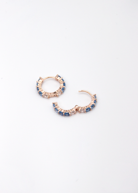 Orecchini hoop in argento con zirconi azzurri e cristallo, cerchi luminosi dal design elegante disponibili in finitura argento, oro e oro rosa, diametro 1,5 cm.