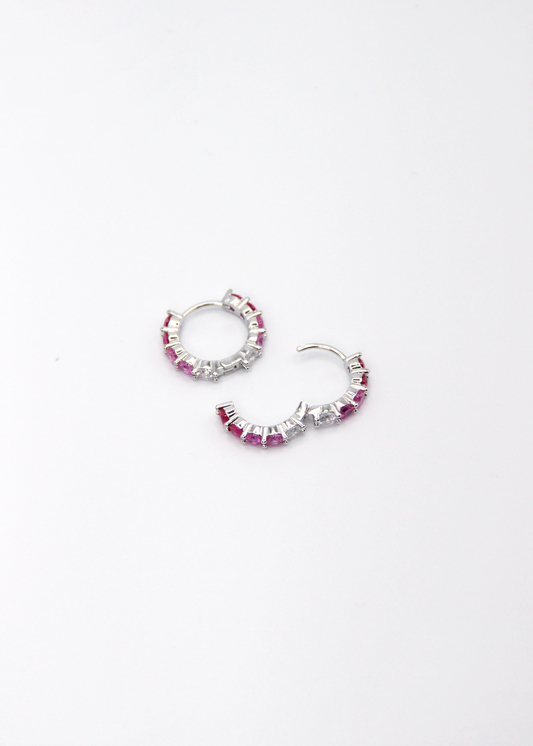 Orecchini hoop in argento con zirconi fucsia e rosa, cerchi luminosi dal design elegante disponibili in finitura argento, oro e oro rosa, diametro 1,5 cm.