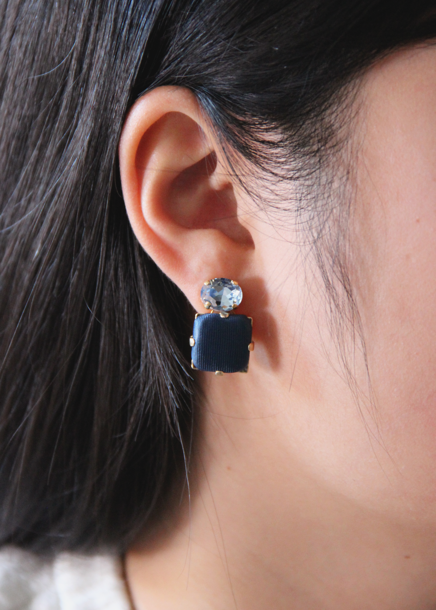 Orecchini blu eleganti fatti a mano da Laura Sciunnach Bijoux, modello Metropolitan Siviglia con bottone quadrato blu notte e cristallo ovale azzurro, design geometrico leggero e raffinato.