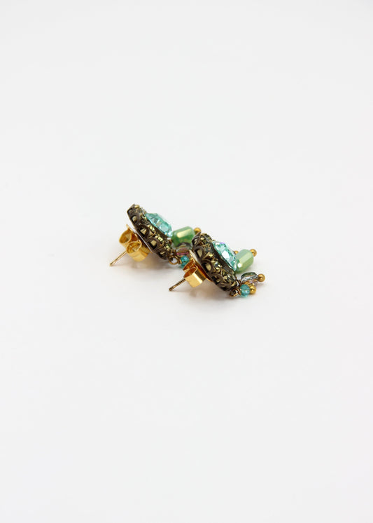 Orecchini artigianali Metropolitan Taormina verde, con cristallo centrale verdeacqua, corona di strass verde oliva e cinque pietre sfaccettate iridescenti a cascata. Nickel free, stile mediterraneo per ogni occasione.