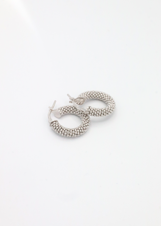 Orecchino a cerchio in argento 925 con piccole rondelle dal design essenziale ed elegante. Diametro 1,5 cm, è dotato di pratica chiusura a baionetta che garantisce comfort e sicurezza. Luminoso e versatile, si abbina perfettamente al bracciale in argento con rondelle chiare per un look coordinato e raffinato, ideale sia per l’uso quotidiano che per occasioni speciali.