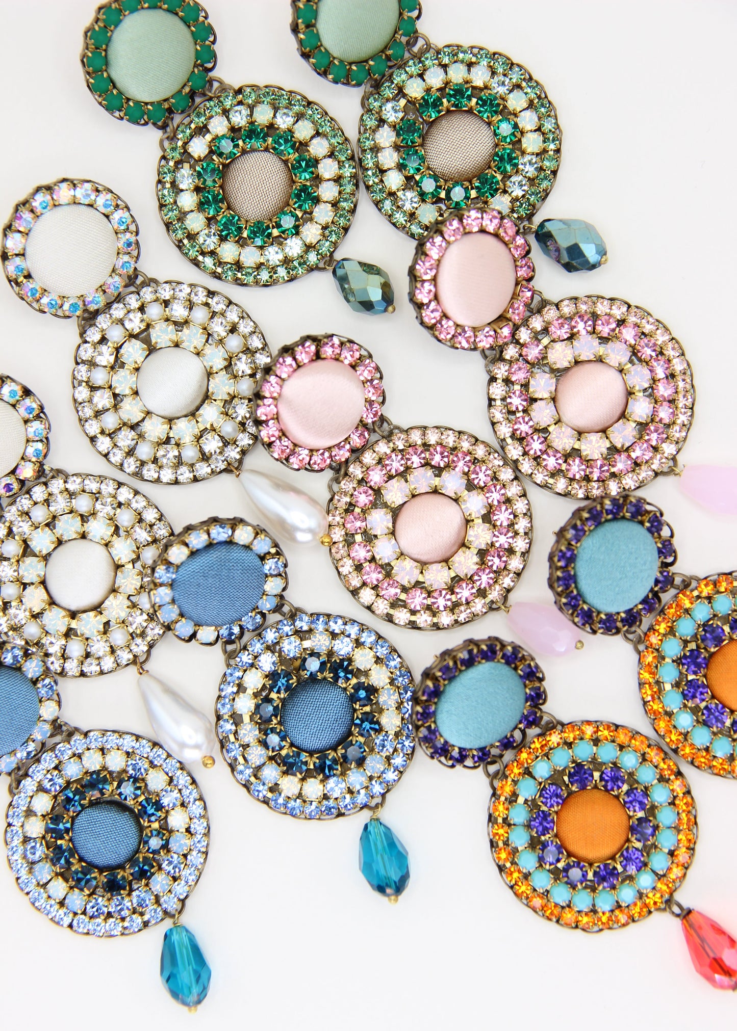 Orecchini artigianali Metropolitan Dubai rosa confetto, con bottoni circolari in tessuto, strass e pendente a goccia in cristallo. Nickel free, ideali per cerimonie ed eventi speciali.