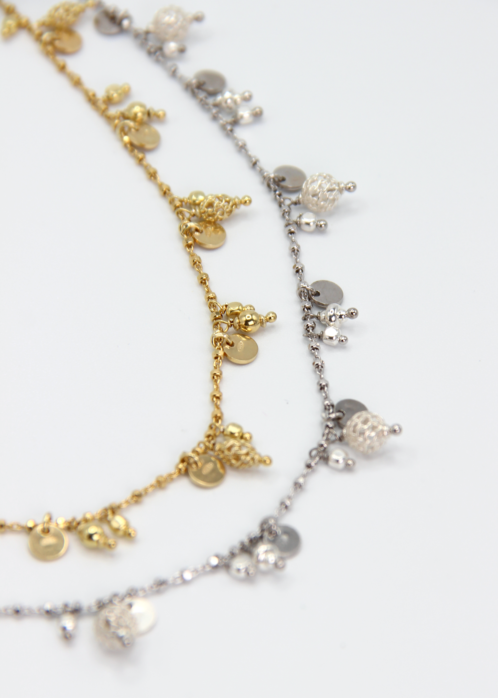 Collana Little Princess Monochrome Laura Sciunnach disponibile in argento 925 e argento placcato oro giallo. Confronto delle due finiture della collana artigianale Made in Italy con ciondoli decorativi.