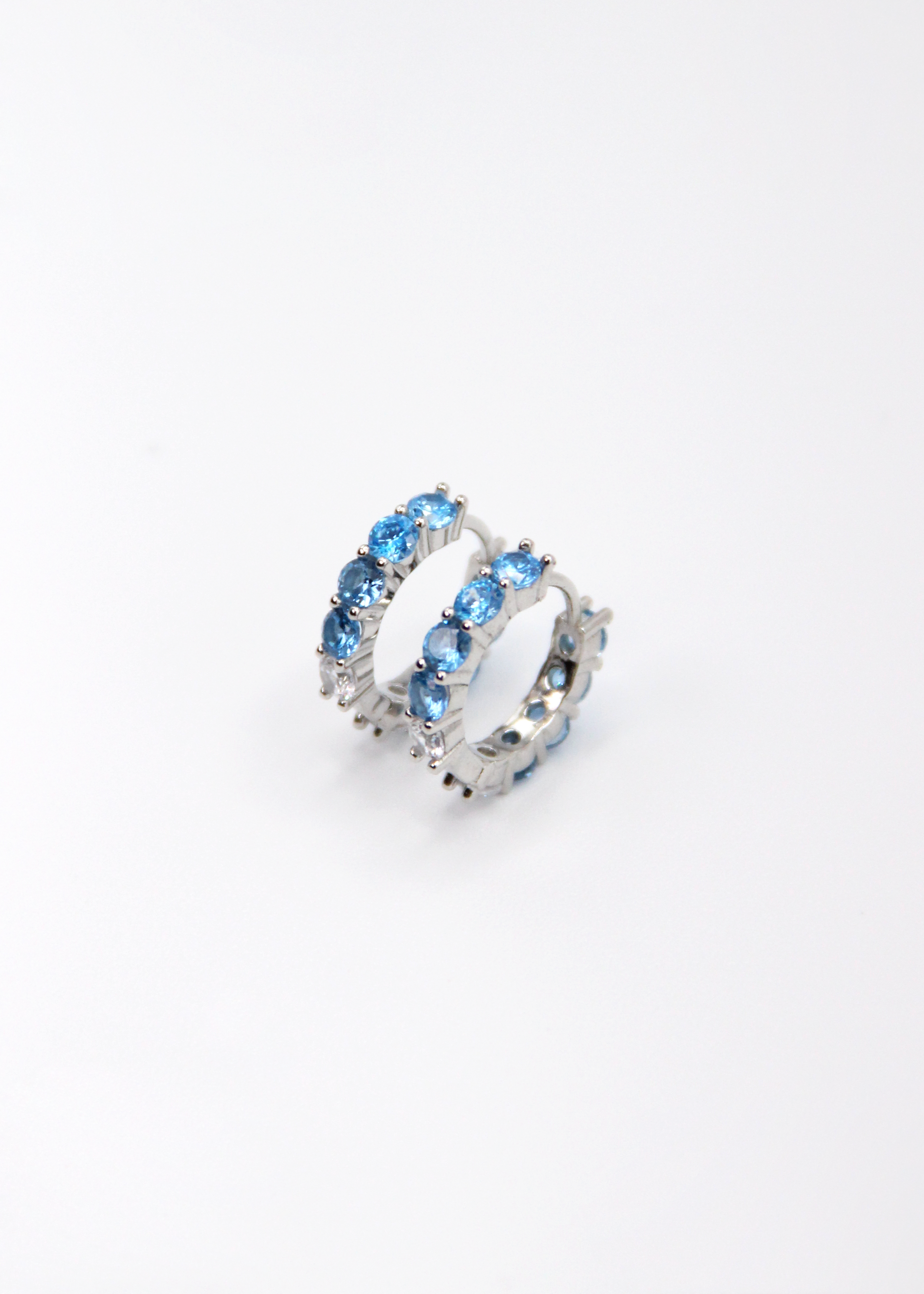 Orecchini hoop in argento con zirconi azzurri e cristallo, cerchi luminosi dal design elegante disponibili in finitura argento, oro e oro rosa, diametro 1,5 cm.