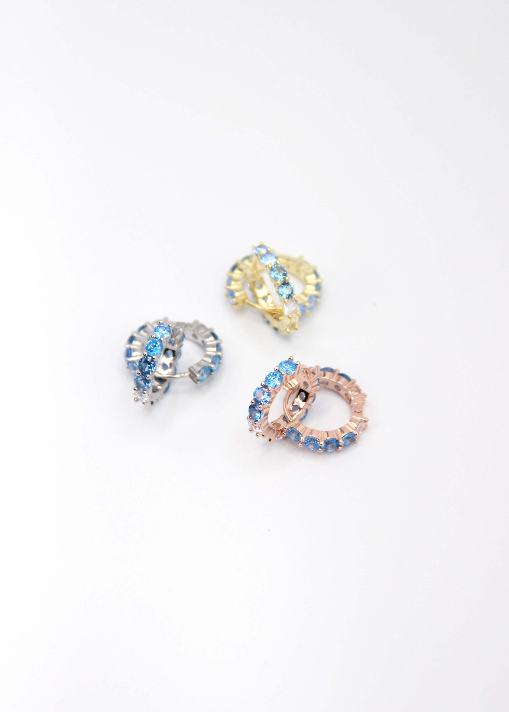 Orecchini hoop in argento con zirconi azzurri e cristallo, cerchi luminosi dal design elegante disponibili in finitura argento, oro e oro rosa, diametro 1,5 cm.