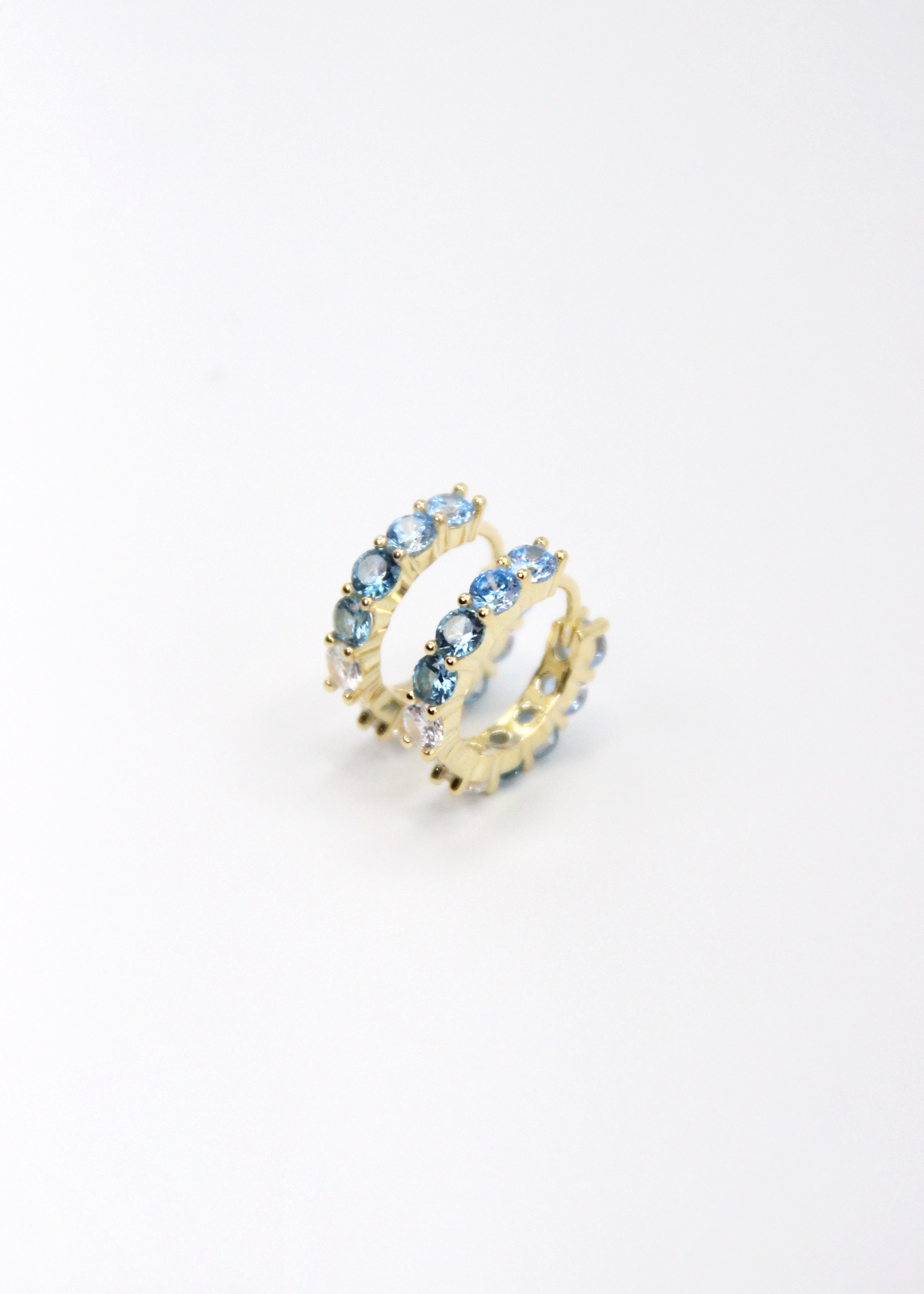 Orecchini hoop in argento con zirconi azzurri e cristallo, cerchi luminosi dal design elegante disponibili in finitura argento, oro e oro rosa, diametro 1,5 cm.