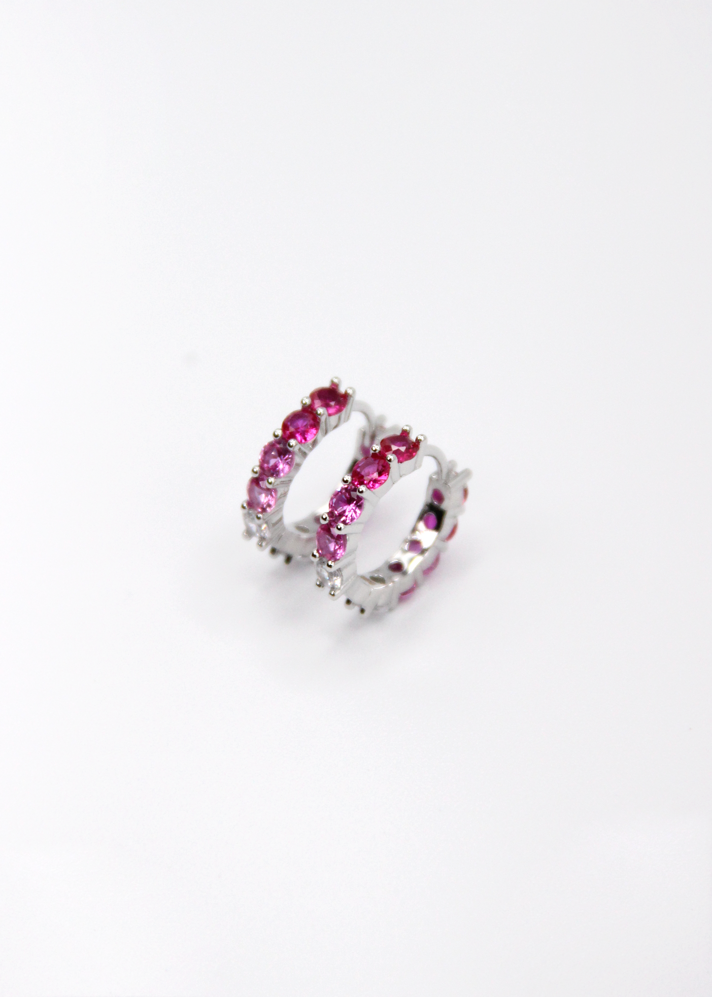 Orecchini hoop in argento con zirconi fucsia e rosa, cerchi luminosi dal design elegante disponibili in finitura argento, oro e oro rosa, diametro 1,5 cm.