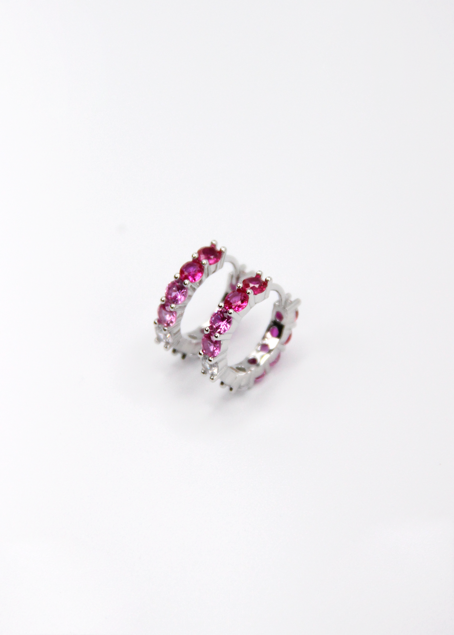 Orecchini hoop in argento con zirconi fucsia e rosa, cerchi luminosi dal design elegante disponibili in finitura argento, oro e oro rosa, diametro 1,5 cm.