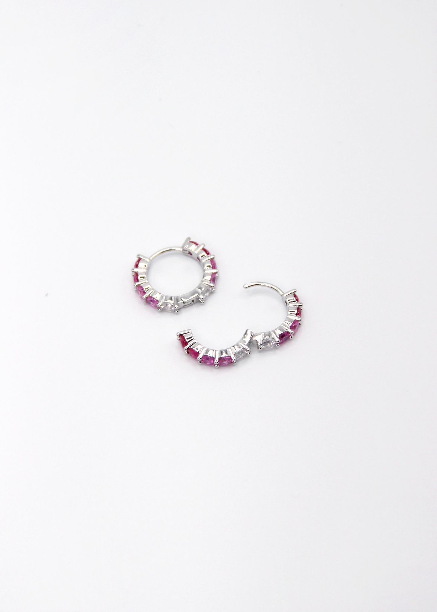 Orecchini hoop in argento con zirconi fucsia e rosa, cerchi luminosi dal design elegante disponibili in finitura argento, oro e oro rosa, diametro 1,5 cm.