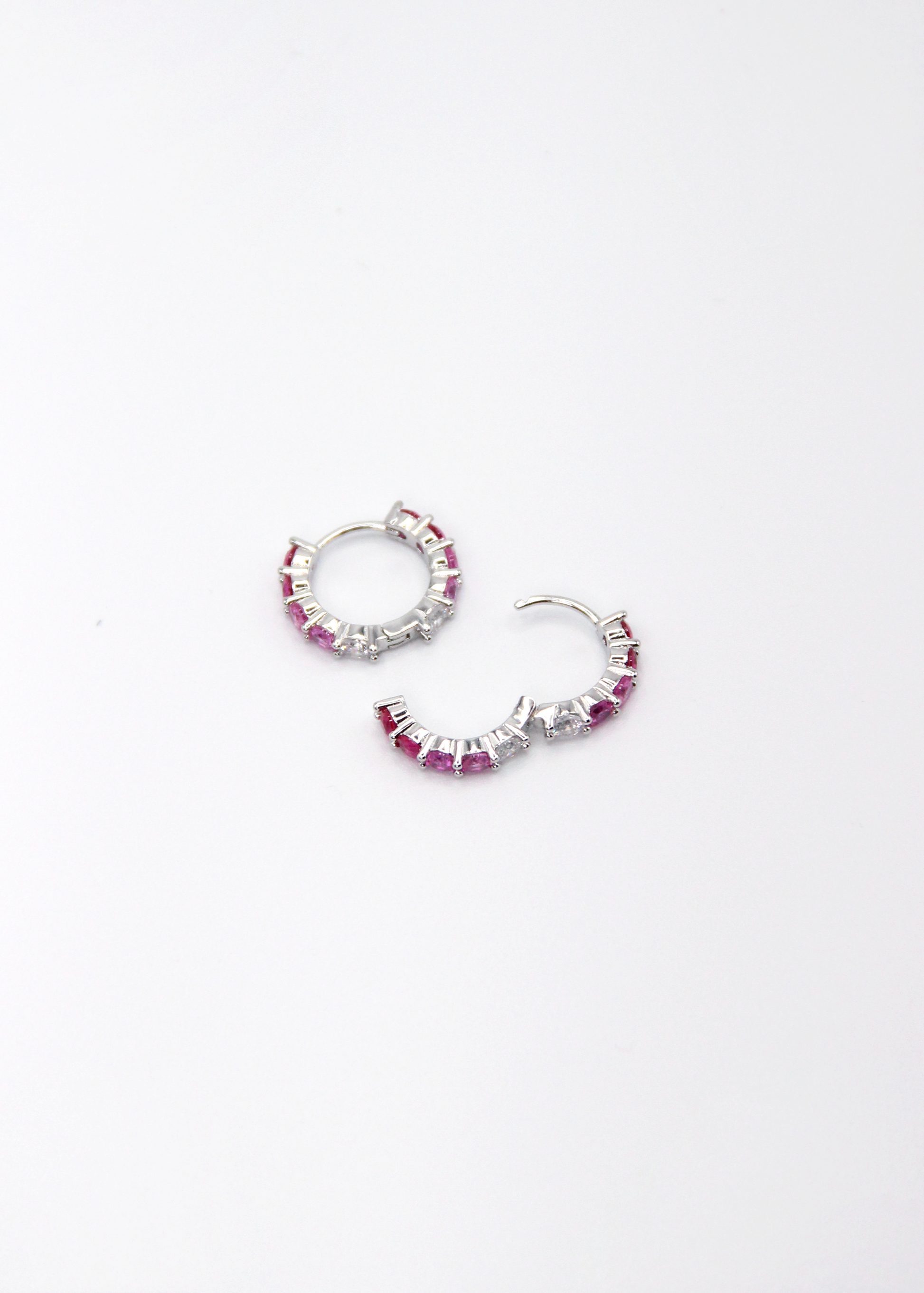 Orecchini hoop in argento con zirconi fucsia e rosa, cerchi luminosi dal design elegante disponibili in finitura argento, oro e oro rosa, diametro 1,5 cm.