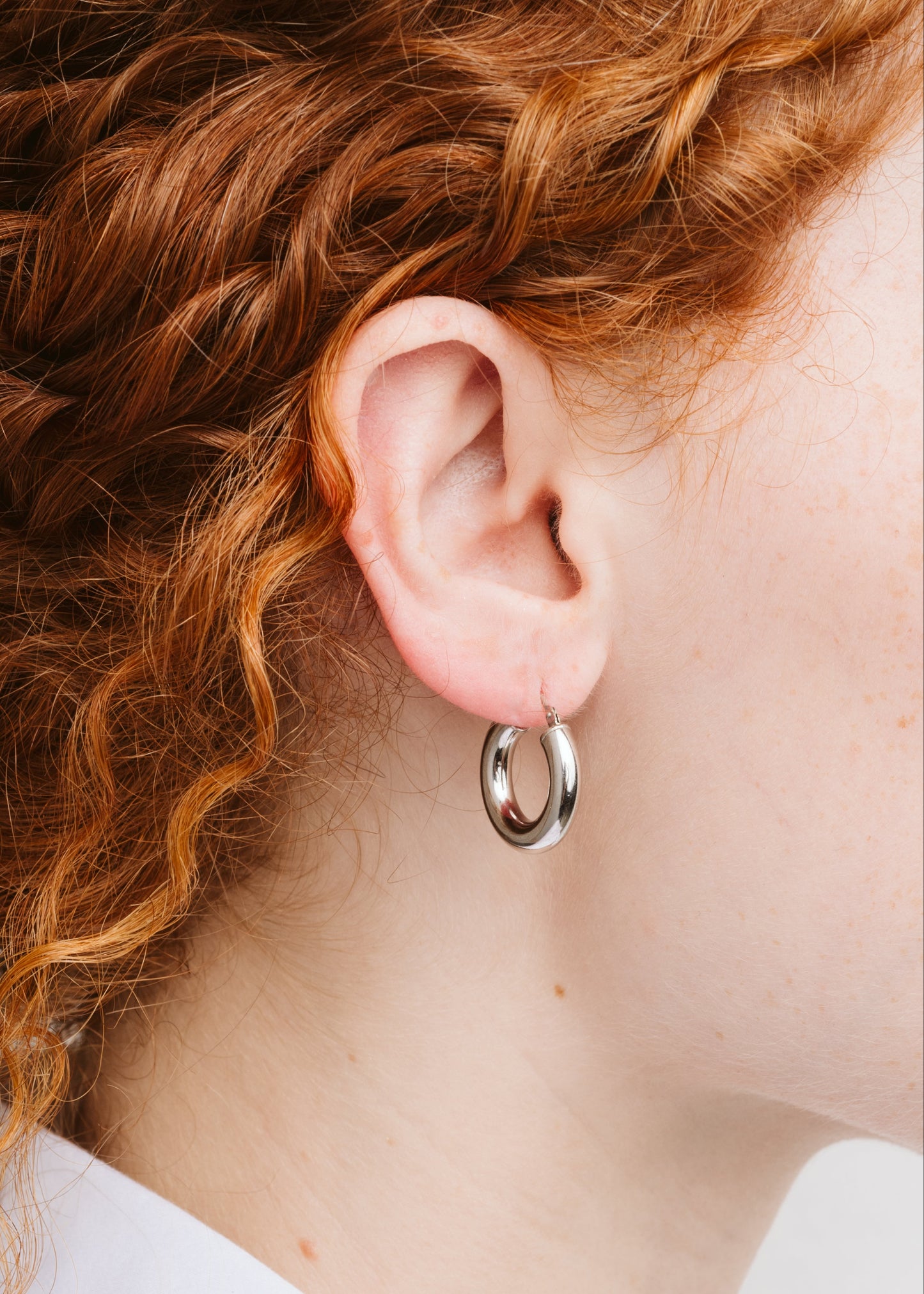 Orecchini a cerchio bombato piccolo in argento 925 nickel free, leggeri e luminosi, con chiusura a forcella, design moderno ed elegante da donna.