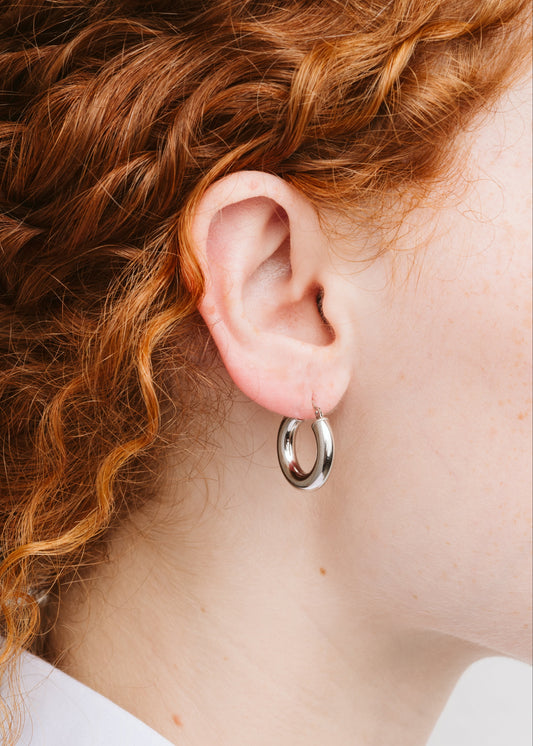 Orecchini a cerchio bombato piccolo in argento 925 nickel free, leggeri e luminosi, con chiusura a forcella, design moderno ed elegante da donna.