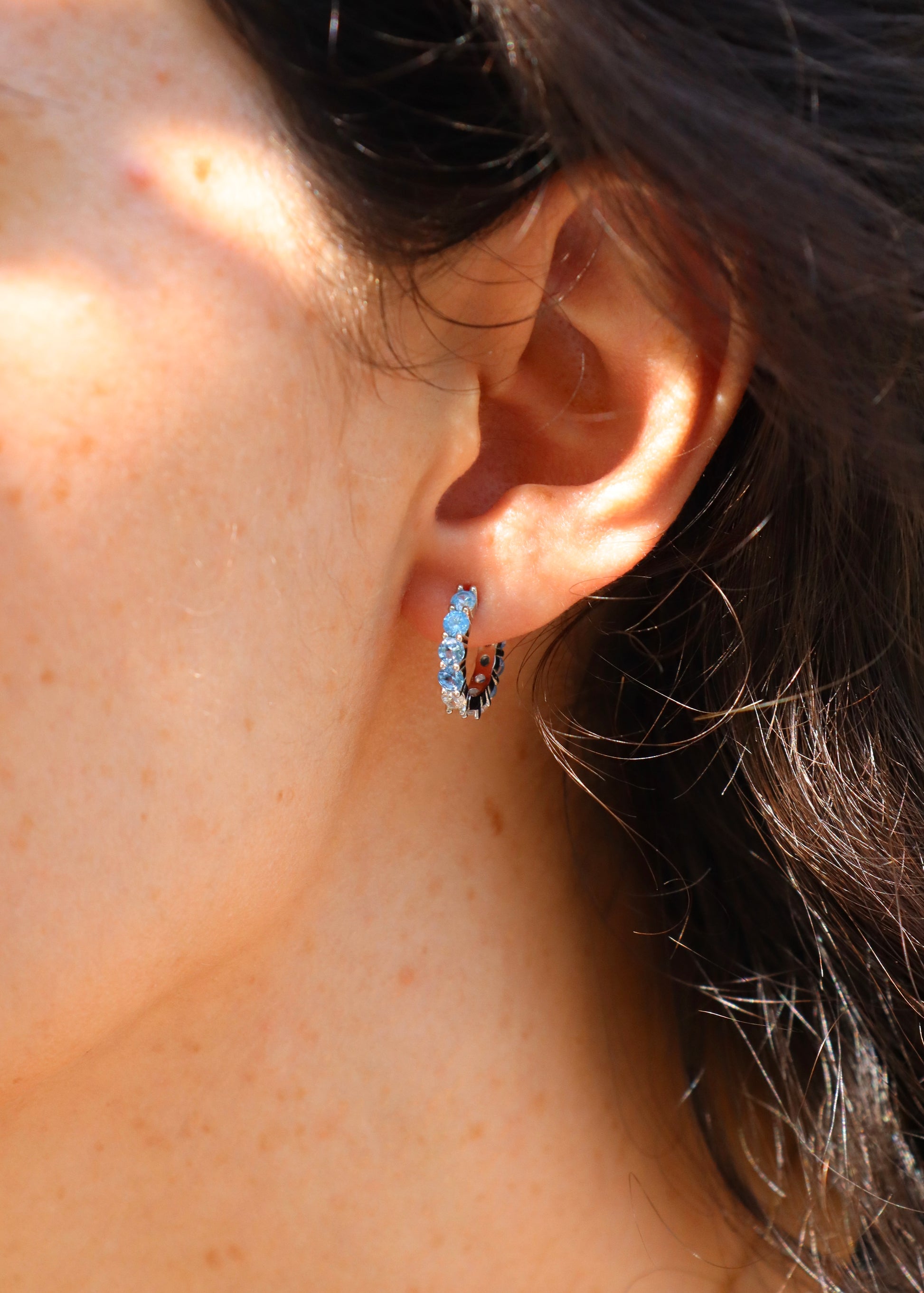 Orecchini hoop in argento con zirconi azzurri e cristallo, cerchi luminosi dal design elegante disponibili in finitura argento, oro e oro rosa, diametro 1,5 cm.