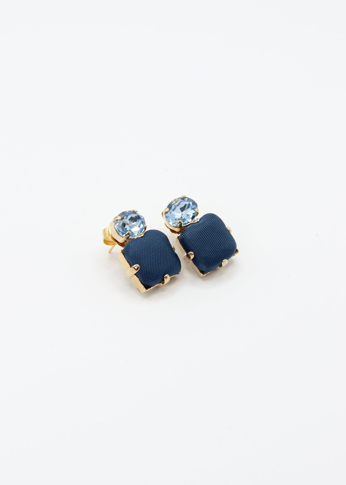 Orecchini blu eleganti fatti a mano da Laura Sciunnach Bijoux, modello Metropolitan Siviglia con bottone quadrato blu notte e cristallo ovale azzurro, design geometrico leggero e raffinato.