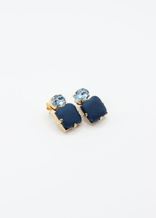 Orecchini blu eleganti fatti a mano da Laura Sciunnach Bijoux, modello Metropolitan Siviglia con bottone quadrato blu notte e cristallo ovale azzurro, design geometrico leggero e raffinato.