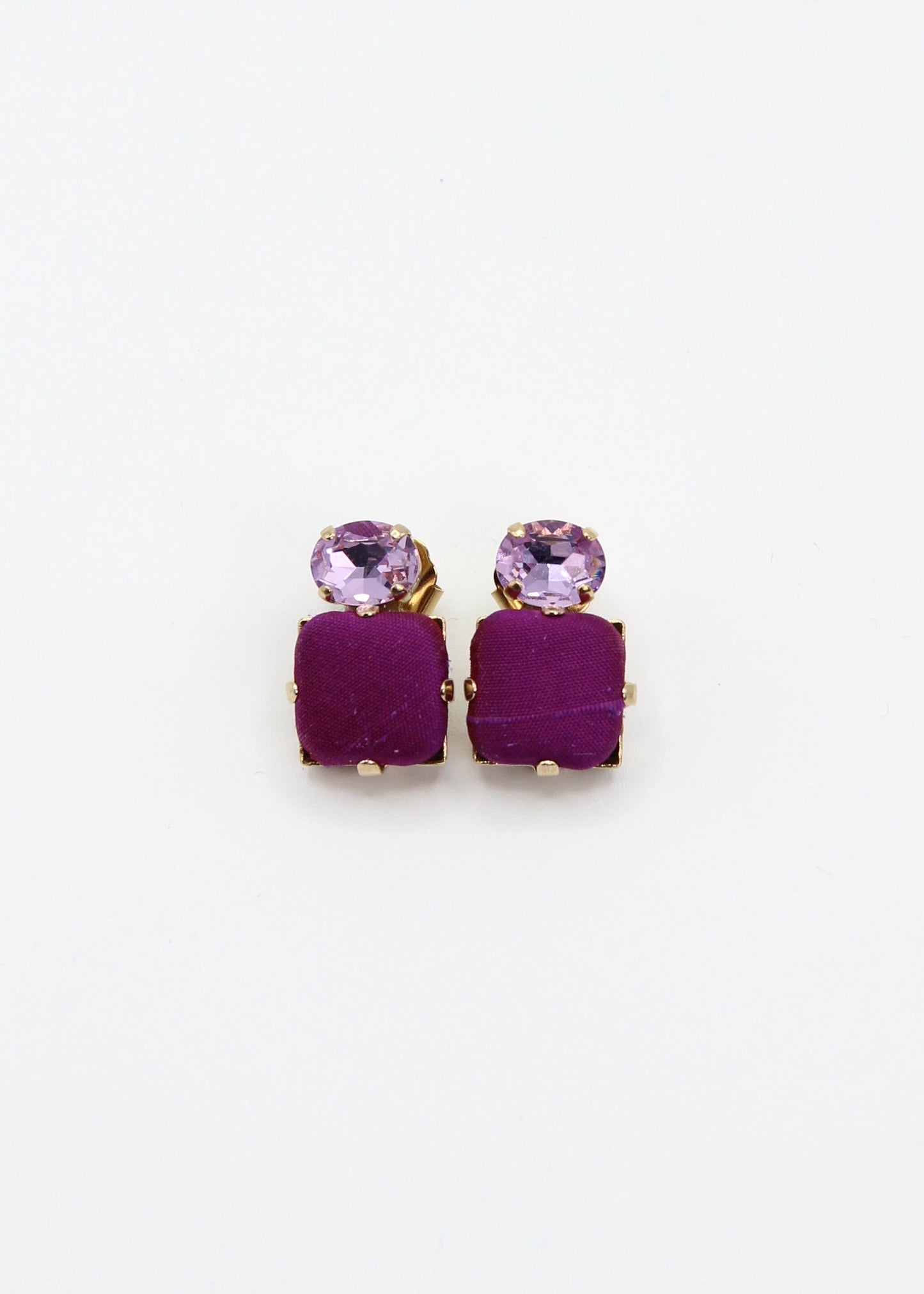Orecchini viola eleganti fatti a mano da Laura Sciunnach Bijoux, modello Metropolitan Siviglia con bottone quadrato in stoffa viola e cristallo ovale lilla, design geometrico leggero e raffinato.