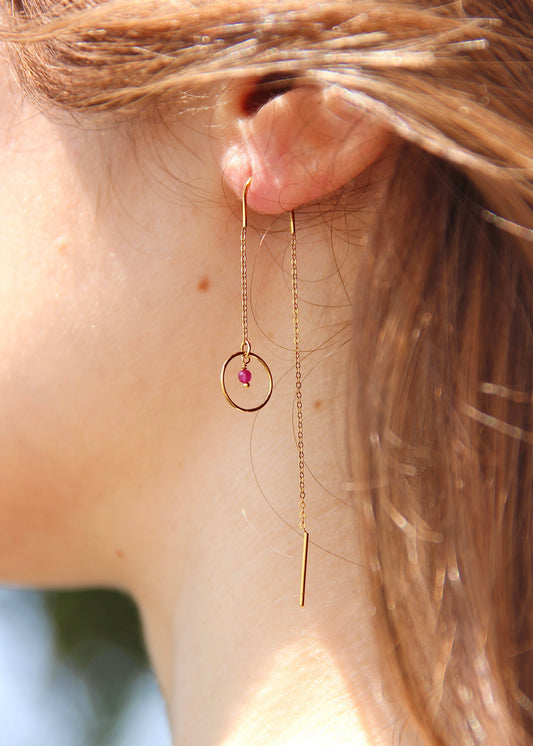 Orecchino saliscendi arco Saturno in acciaio dorato con archetto rigido, catena sottile e ciondolo a cerchio con pietra centrale, design elegante e minimalista.