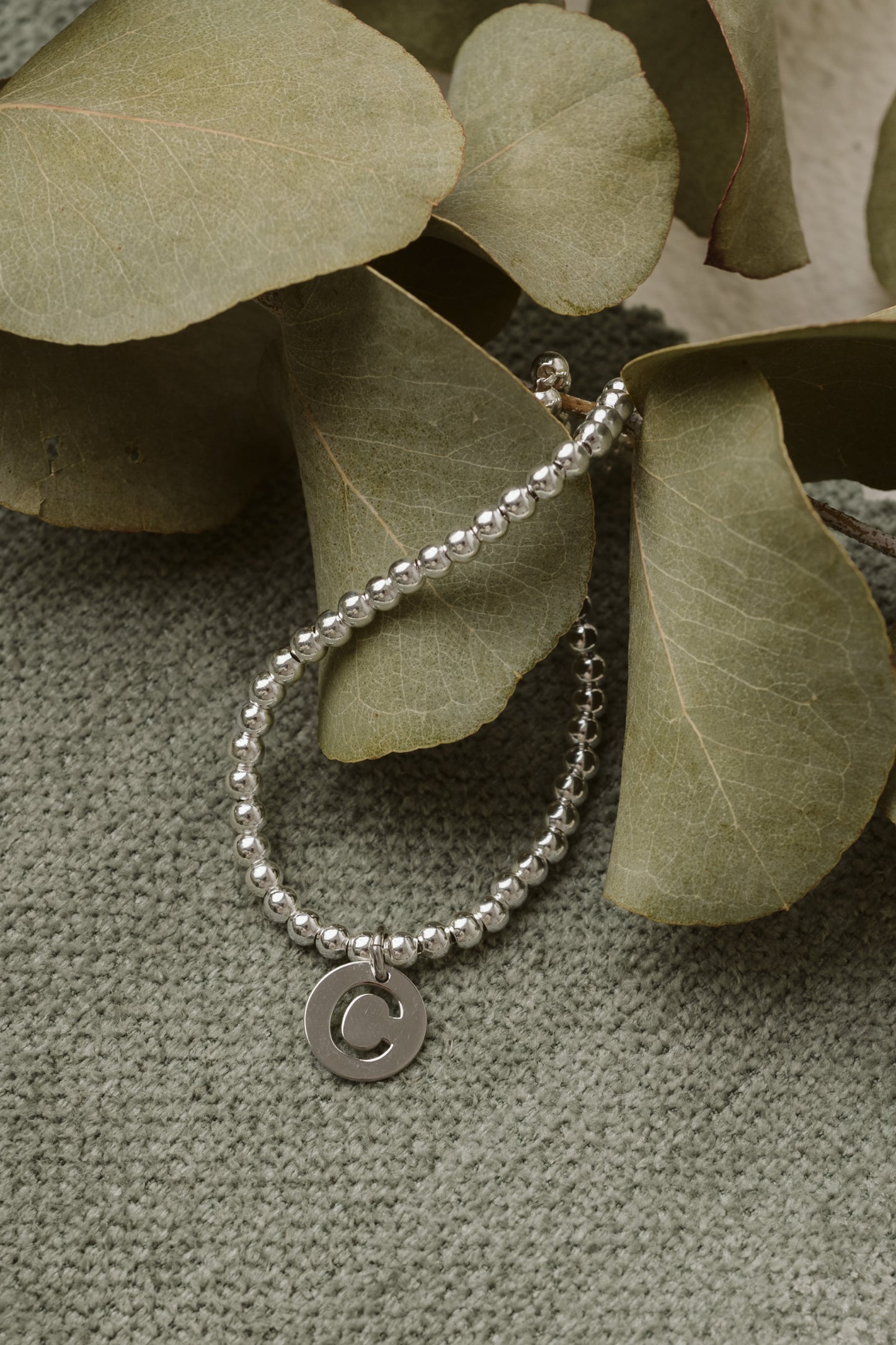 Silver bracelet with small beads and letter