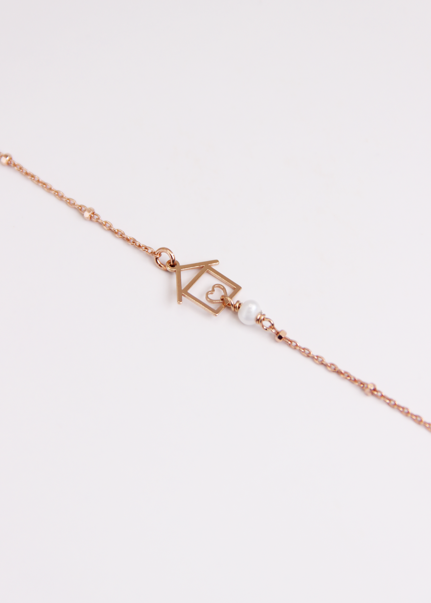 Bracciale artigianale fatto a mano da Laura Sciunnach Bijoux in argento 925, con catena rosario e ciondolo a forma di casetta con pietra dura naturale. Disponibile in perla di lago, radice di rubino, agata nera e agata verde, e nelle varianti argento, argento placcato oro e oro rosa. Chiusura a moschettone, lunghezza regolabile