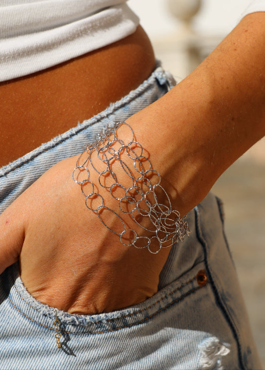 Bracciale Intreccio di Laura Sciunnach, artigianale, cinque fili a maglie irregolari in argento 925, oro giallo o oro rosa, con piccola monetina pendente, elegante e contemporaneo.