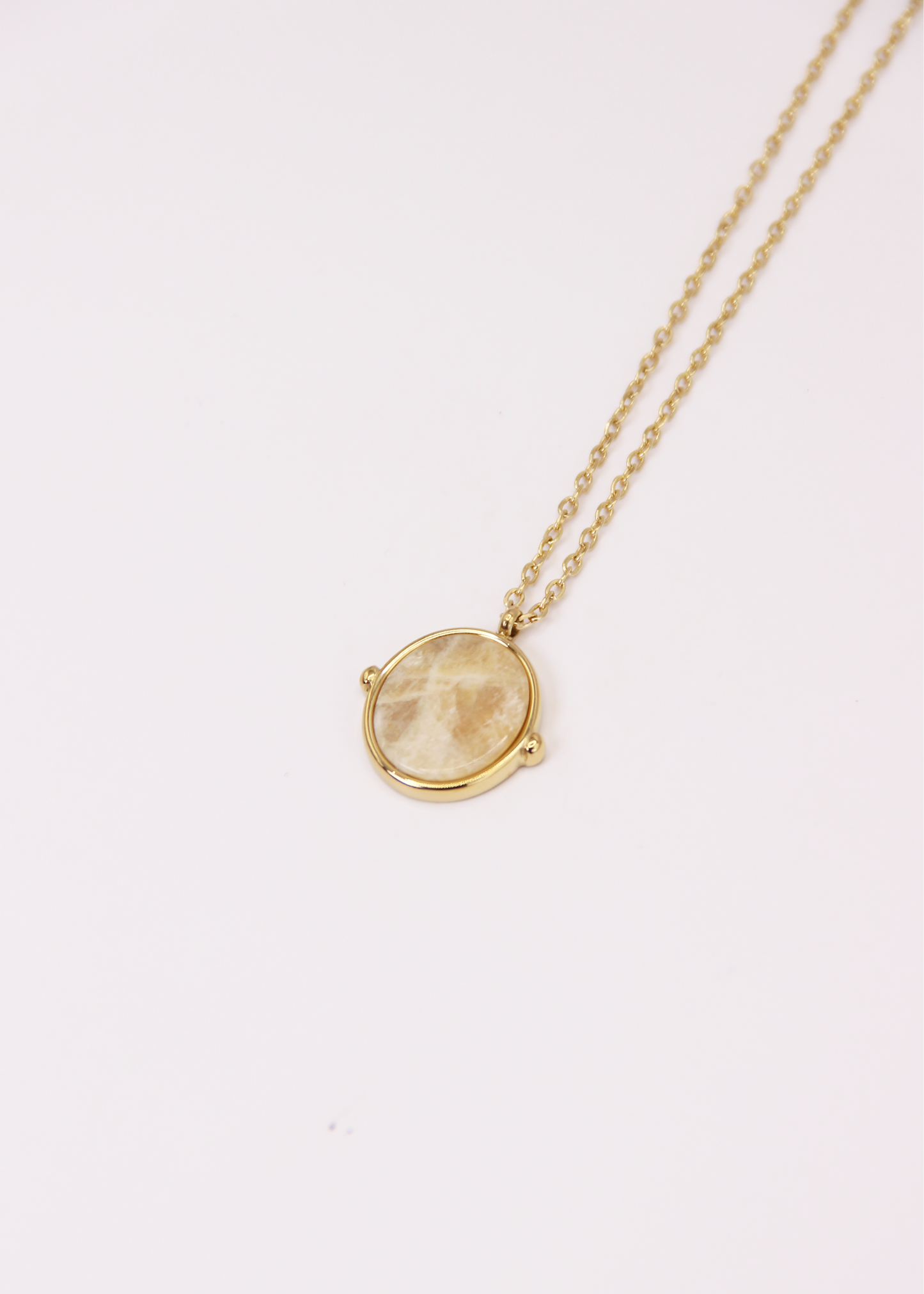 Collana in acciaio placcato oro con ciondolo ovale in pietra dura naturale e catena a maglia rettangolare fine. Disponibile in diversi colori, dal design elegante e senza tempo. Ogni pietra presenta variazioni naturali di colore e venature