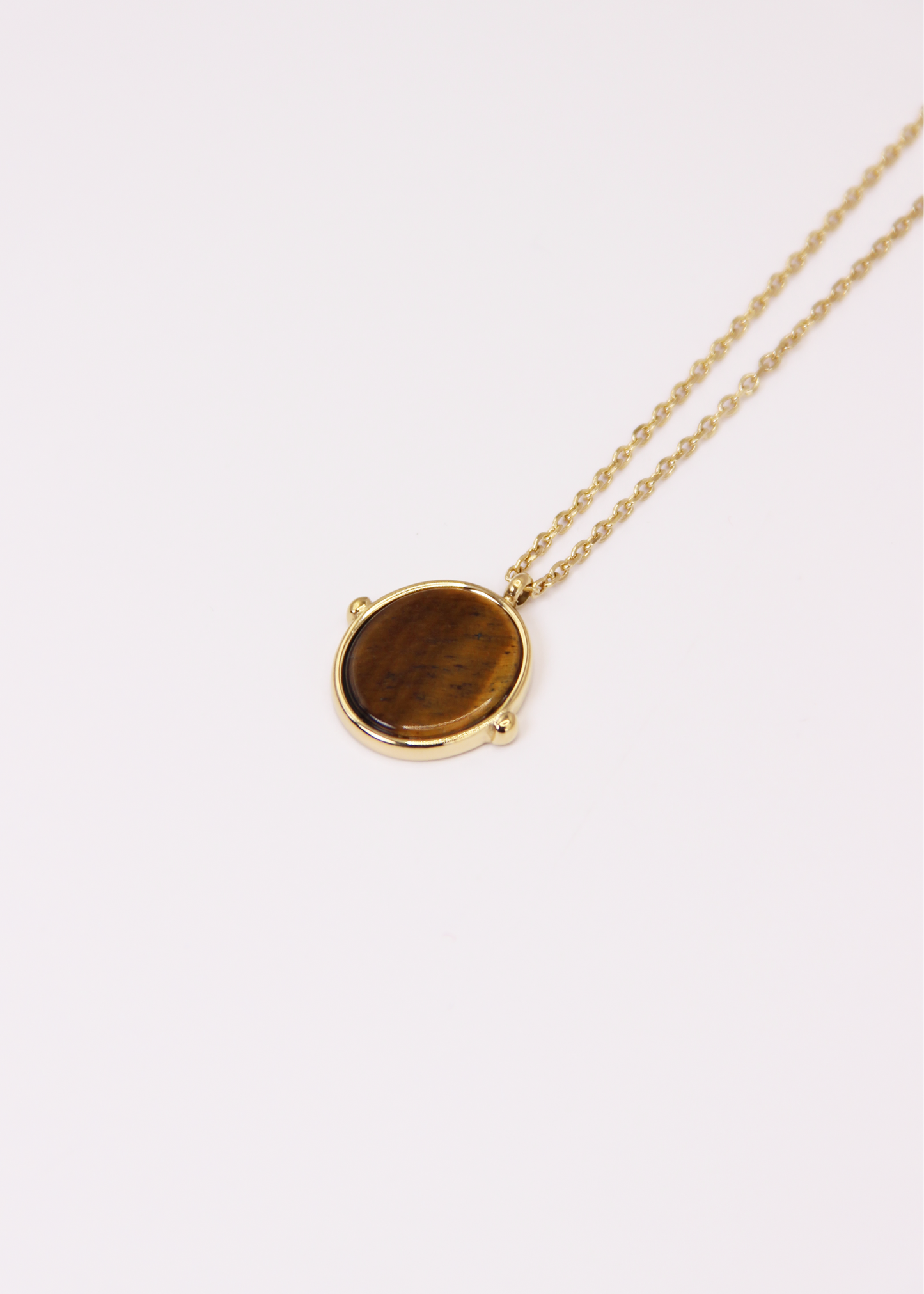 Collana in acciaio placcato oro con ciondolo ovale in pietra dura naturale e catena a maglia rettangolare fine. Disponibile in diversi colori, dal design elegante e senza tempo. Ogni pietra presenta variazioni naturali di colore e venature