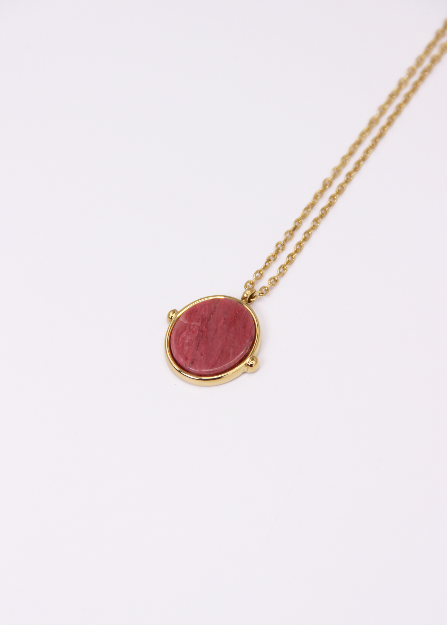 Collana in acciaio placcato oro con ciondolo ovale in pietra dura naturale e catena a maglia rettangolare fine. Disponibile in diversi colori, dal design elegante e senza tempo. Ogni pietra presenta variazioni naturali di colore e venature