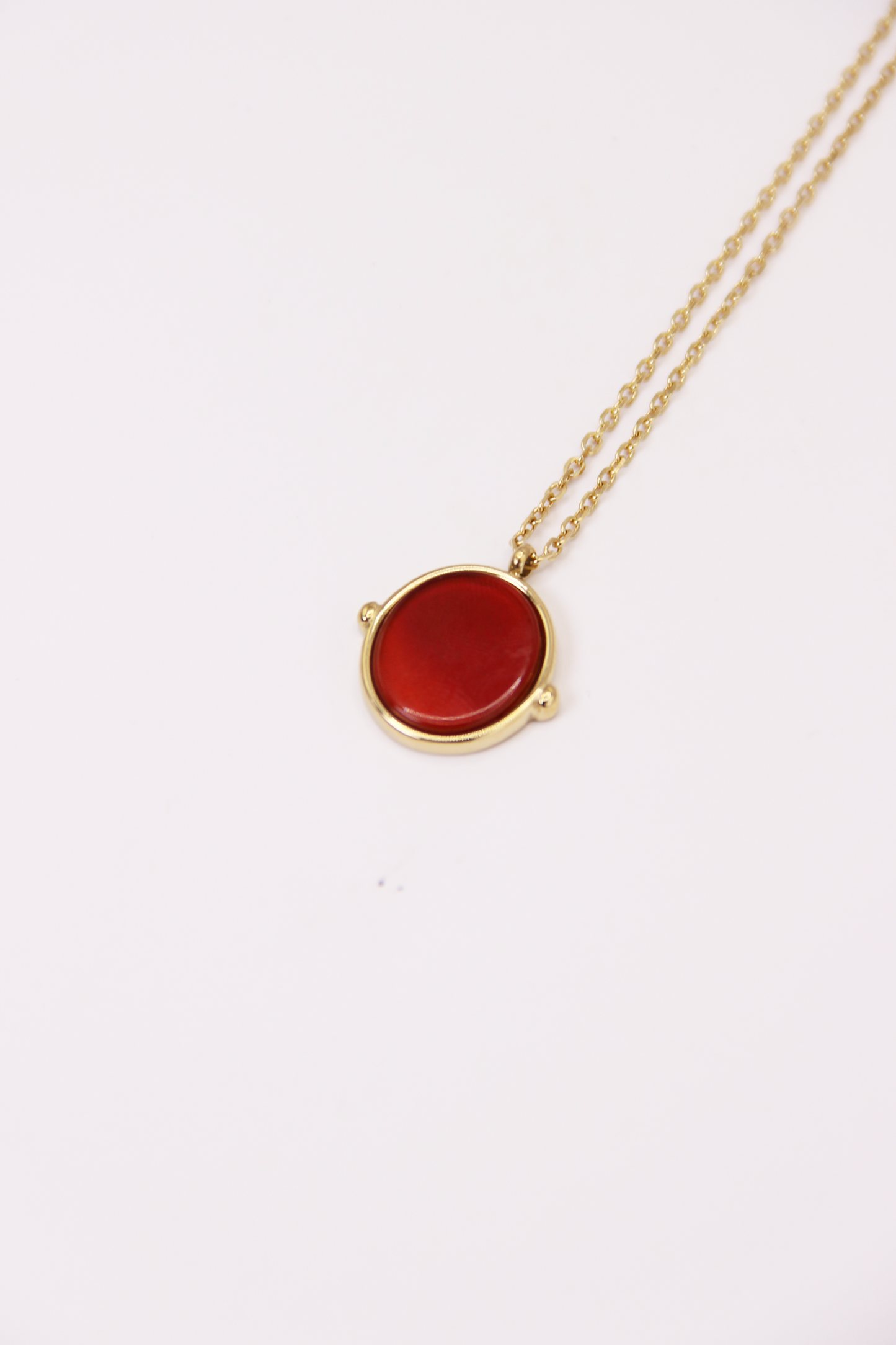 Collana in acciaio placcato oro con ciondolo ovale in pietra dura naturale e catena a maglia rettangolare fine. Disponibile in diversi colori, dal design elegante e senza tempo. Ogni pietra presenta variazioni naturali di colore e venature