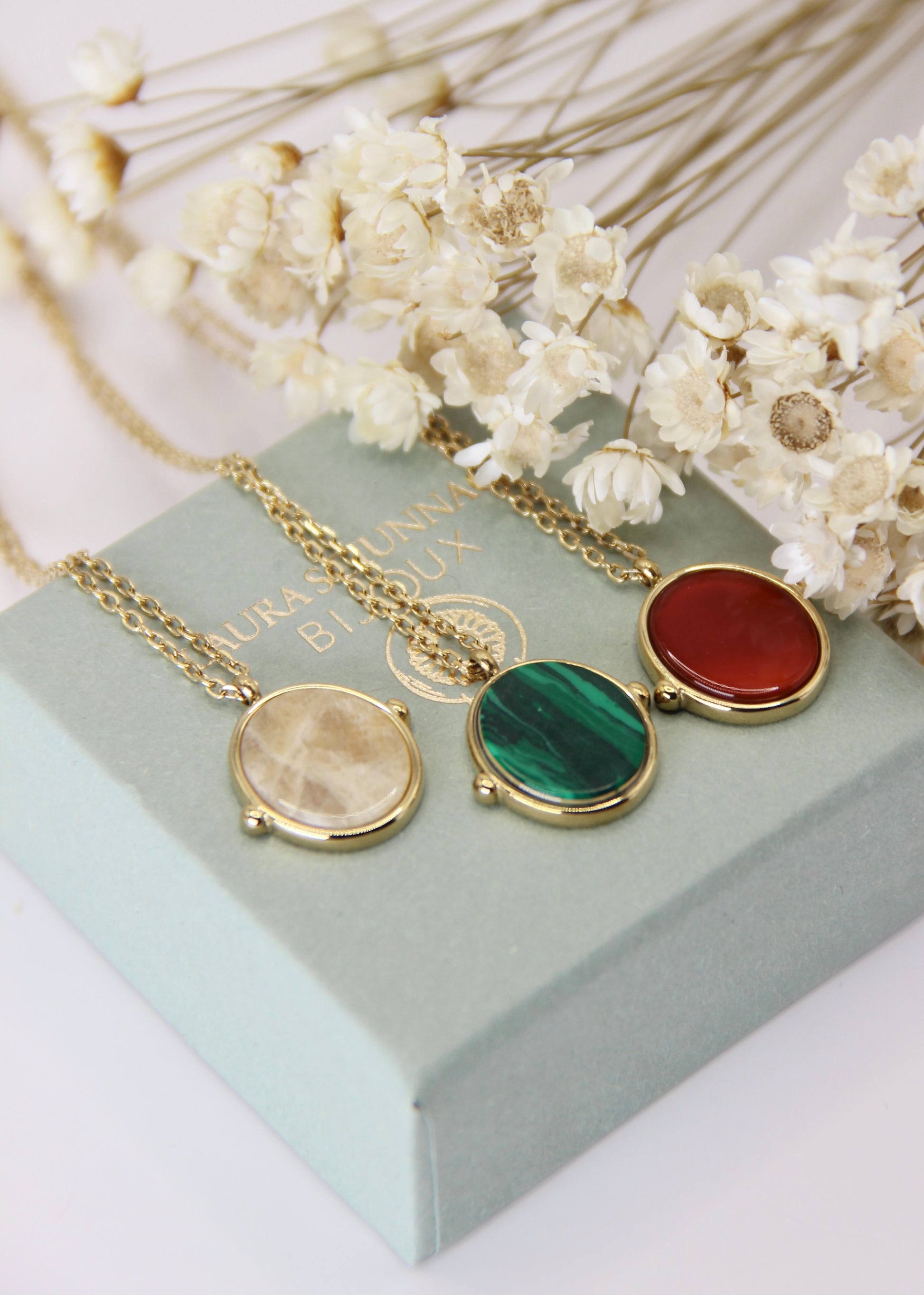 Collana in acciaio placcato oro con ciondolo ovale in pietra dura naturale e catena a maglia rettangolare fine. Disponibile in diversi colori, dal design elegante e senza tempo. Ogni pietra presenta variazioni naturali di colore e venature