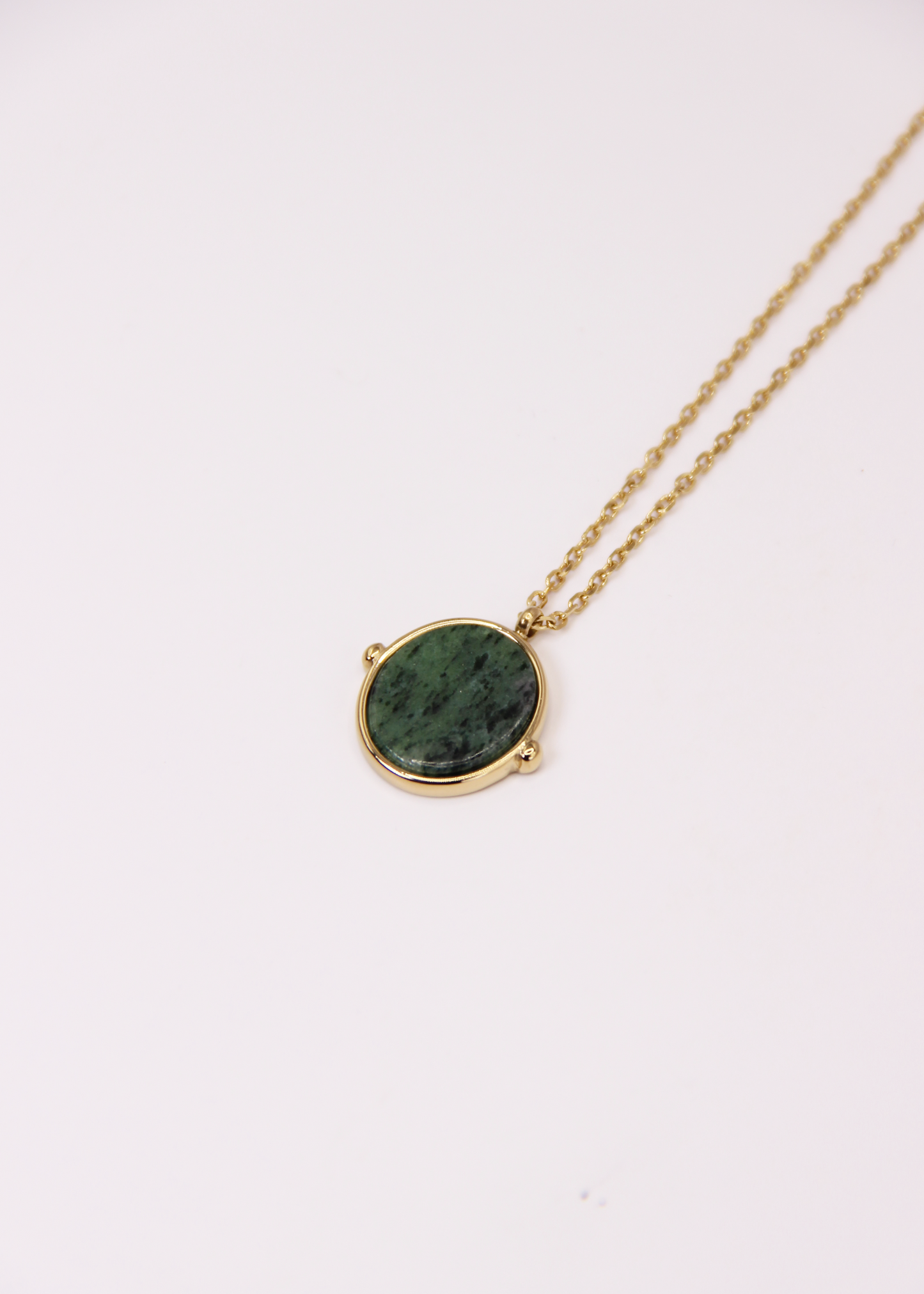 Collana in acciaio placcato oro con ciondolo ovale in pietra dura naturale e catena a maglia rettangolare fine. Disponibile in diversi colori, dal design elegante e senza tempo. Ogni pietra presenta variazioni naturali di colore e venature