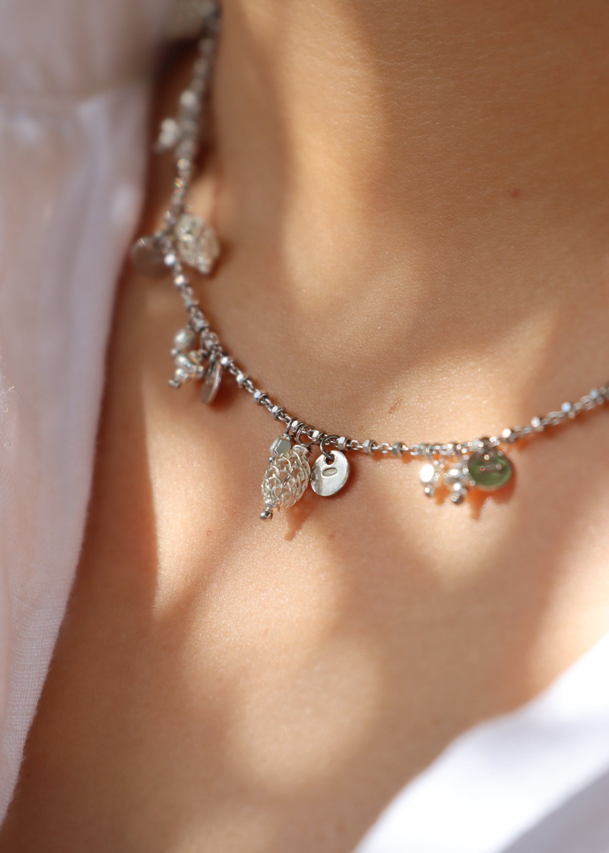 Collana Little Princess Monochrome Laura Sciunnach in argento 925 con ciondoli a pepite, medagliette e trafori, gioiello Made in Italy dal design elegante e moderno.