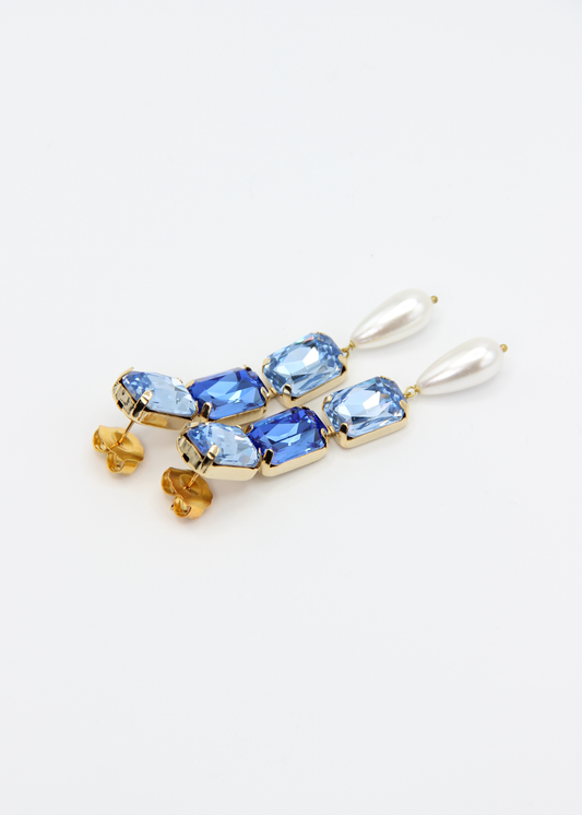Orecchini lunghi Confetti Cremino Laura Sciunnach in tonalità azzurro e blu, con cristalli sfumati tono su tono e pendente a goccia in perla. Gioielli artigianali luminosi ed eleganti.