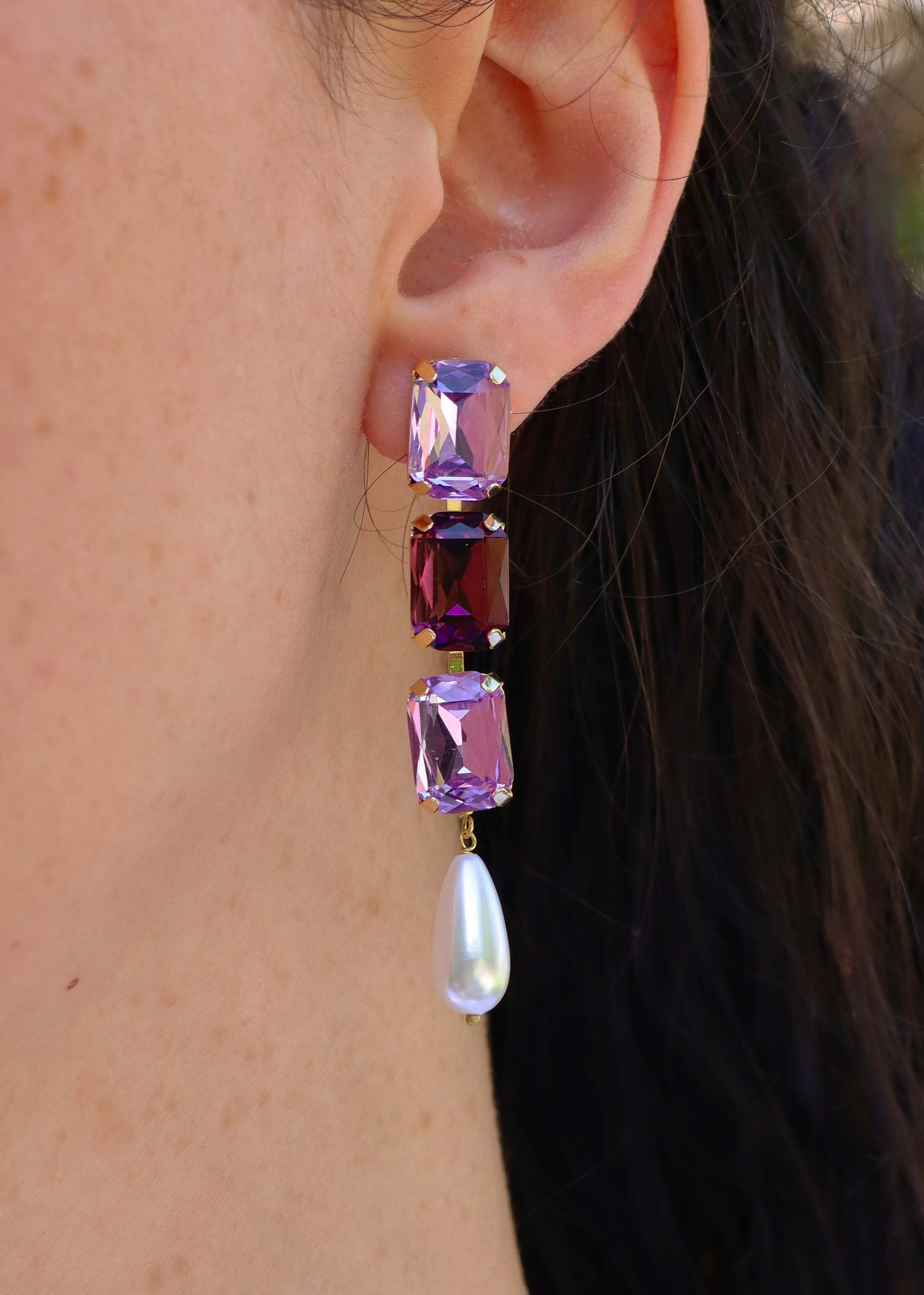 Orecchini lunghi Confetti Cremino Laura Sciunnach in tonalità viola e lilla, con cristalli sfumati tono su tono e pendente a goccia in perla. Gioielli artigianali luminosi ed eleganti.