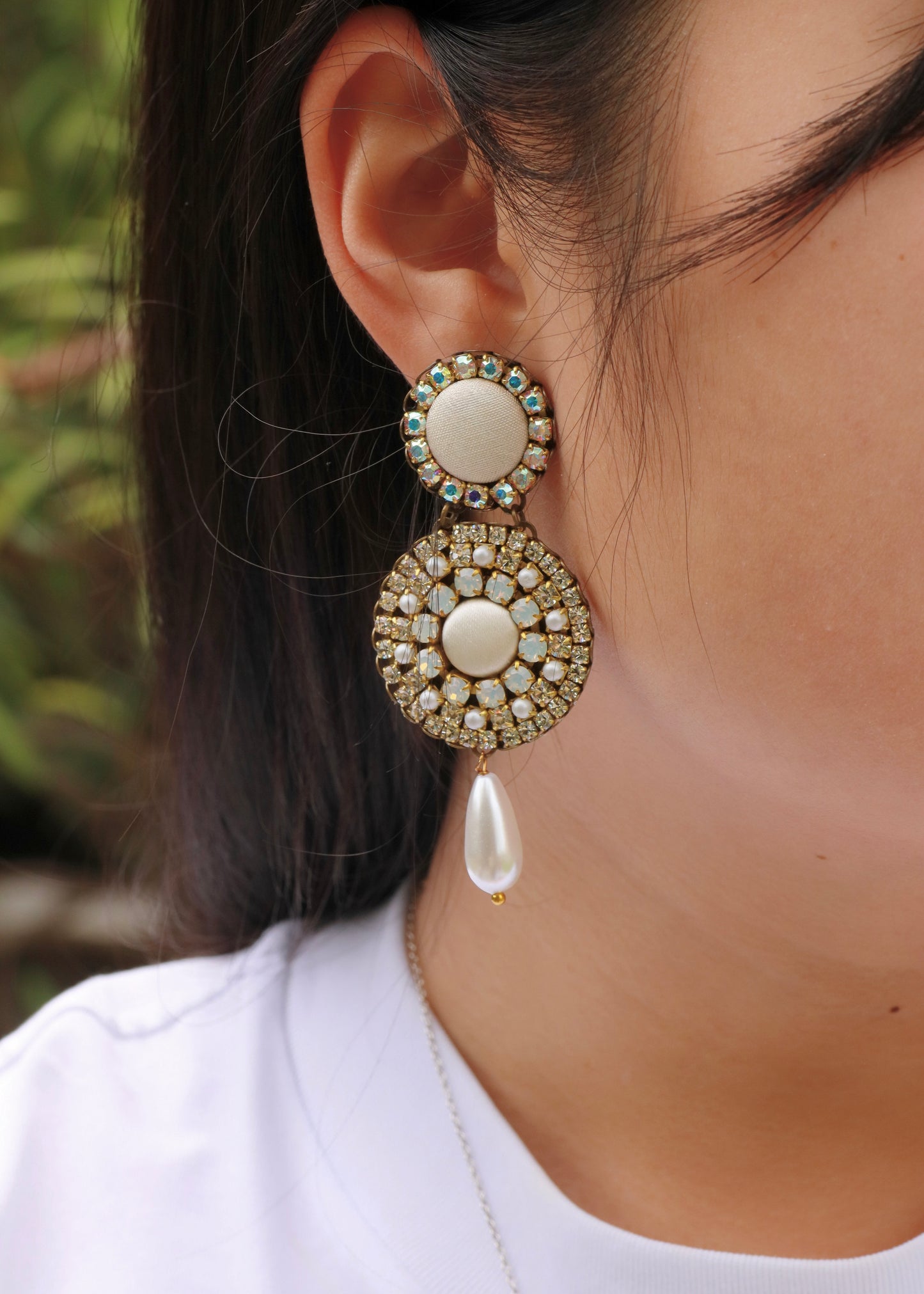 Orecchini artigianali Metropolitan Dubai avorio, con bottoni circolari in tessuto, cristalli iridescenti e pendente a goccia in perla. Nickel free, ideali per cerimonie ed eventi speciali.
