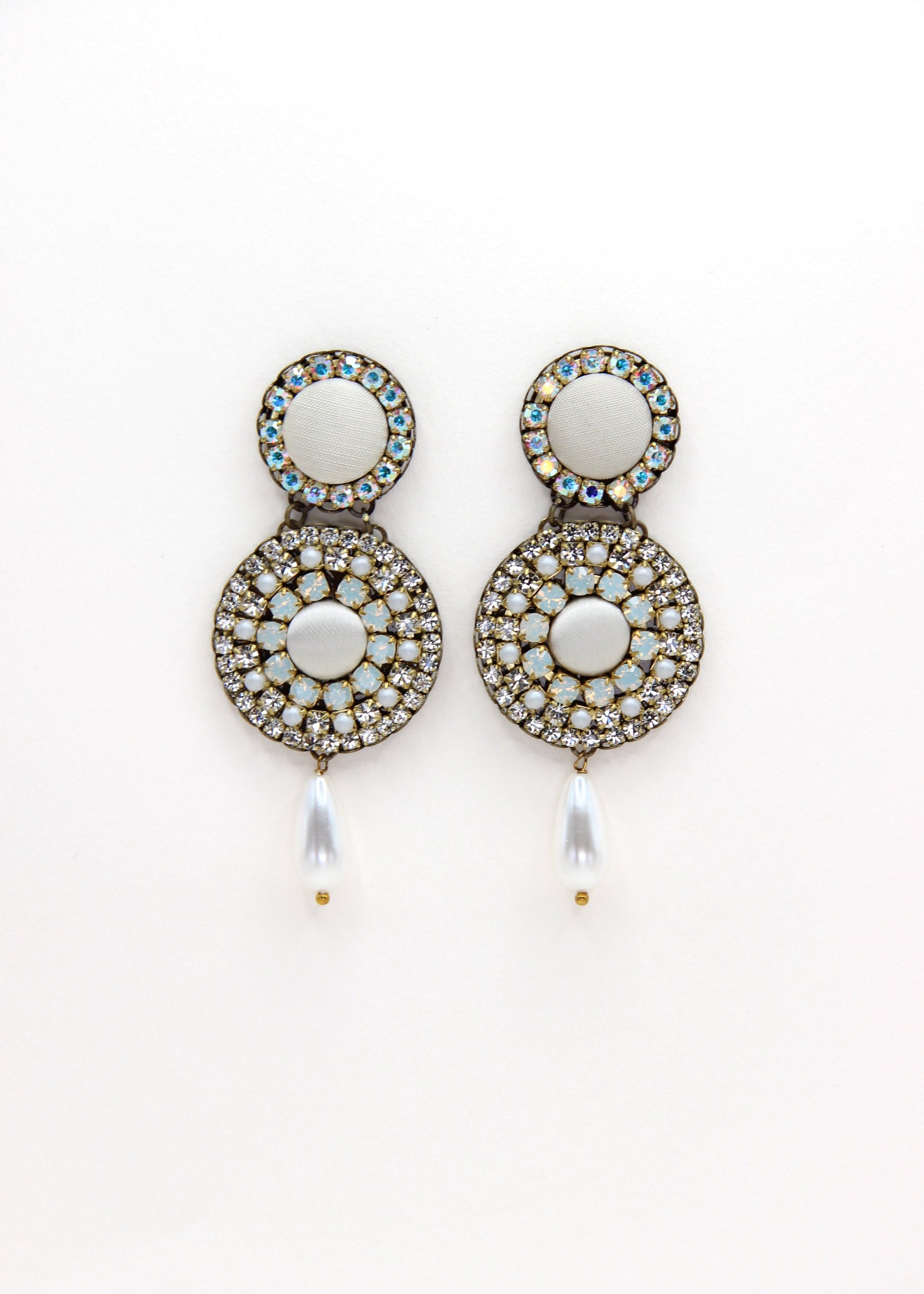 Orecchini artigianali Metropolitan Dubai avorio, con bottoni circolari in tessuto, cristalli iridescenti e pendente a goccia in perla. Nickel free, ideali per cerimonie ed eventi speciali.