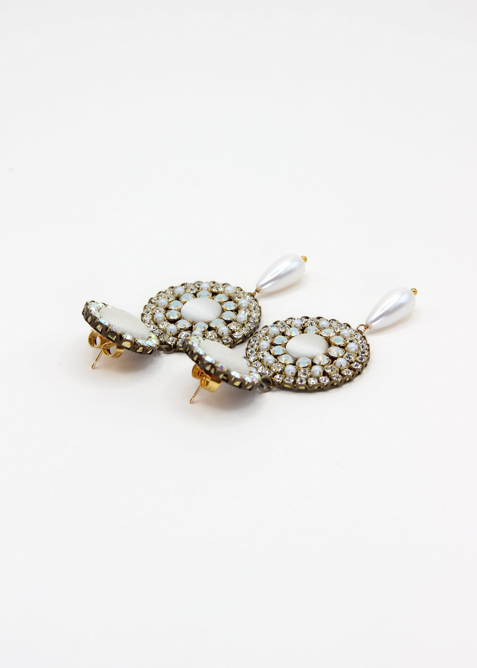 Orecchini artigianali Metropolitan Dubai avorio, con bottoni circolari in tessuto, cristalli iridescenti e pendente a goccia in perla. Nickel free, ideali per cerimonie ed eventi speciali.