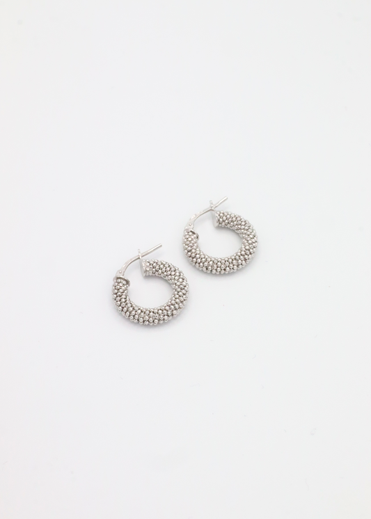 Orecchino a cerchio in argento 925 con piccole rondelle dal design essenziale ed elegante. Diametro 1,5 cm, è dotato di pratica chiusura a baionetta che garantisce comfort e sicurezza. Luminoso e versatile, si abbina perfettamente al bracciale in argento con rondelle chiare per un look coordinato e raffinato, ideale sia per l’uso quotidiano che per occasioni speciali.