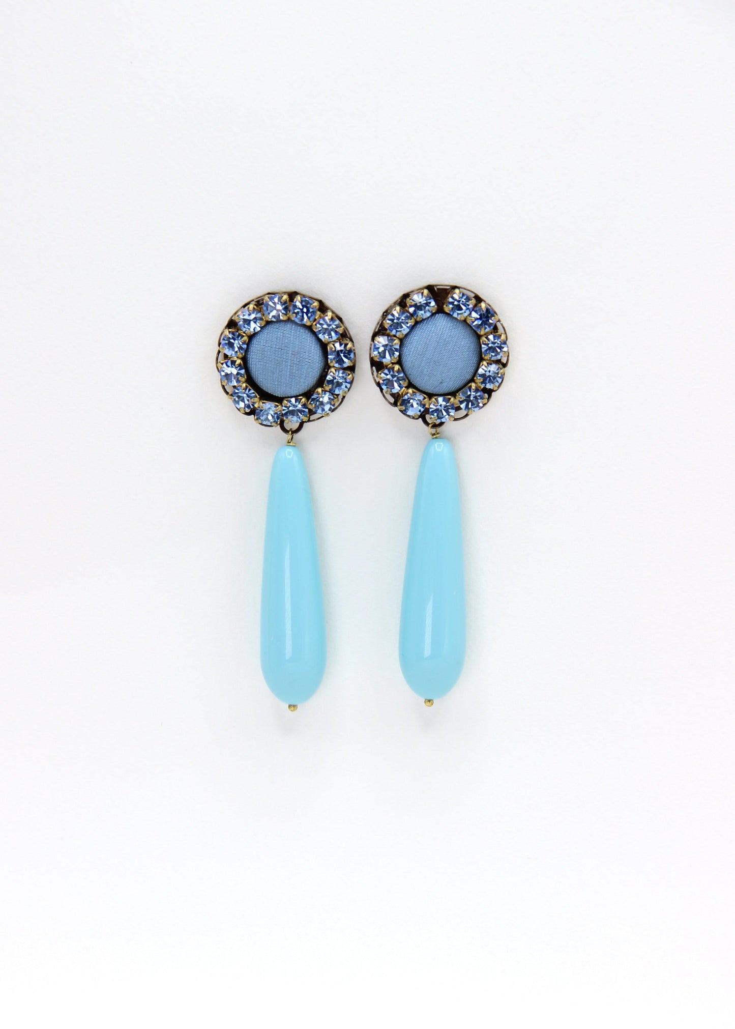 Orecchini artigianali Metropolitan Amalfi azzurro, con bottone circolare in tessuto carta da zucchero, corona di strass azzurri e goccia pendente in resina tono su tono. Nickel free, stile mediterraneo per ogni occasione.