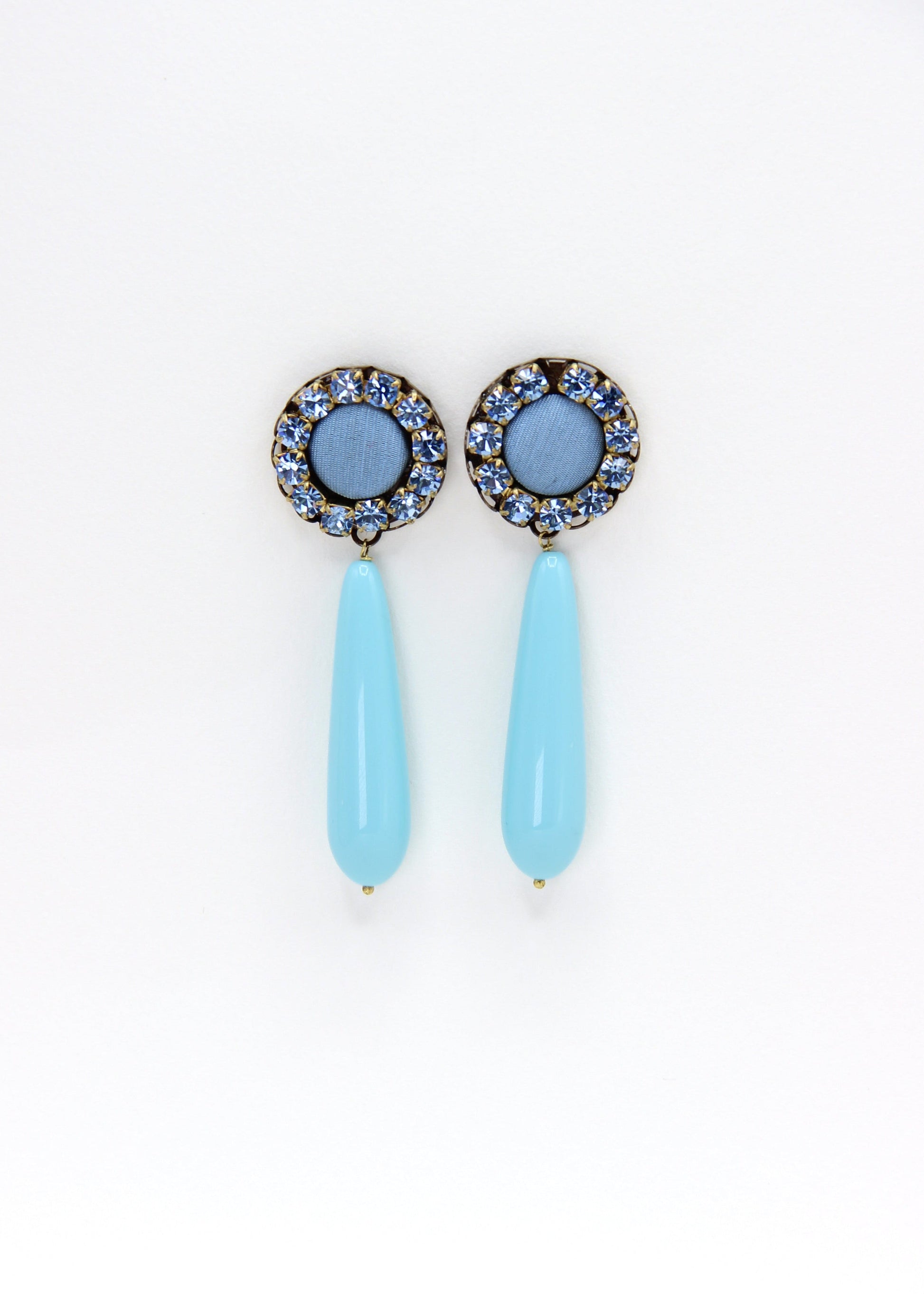 Orecchini artigianali Metropolitan Amalfi azzurro, con bottone circolare in tessuto carta da zucchero, corona di strass azzurri e goccia pendente in resina tono su tono. Nickel free, stile mediterraneo per ogni occasione.