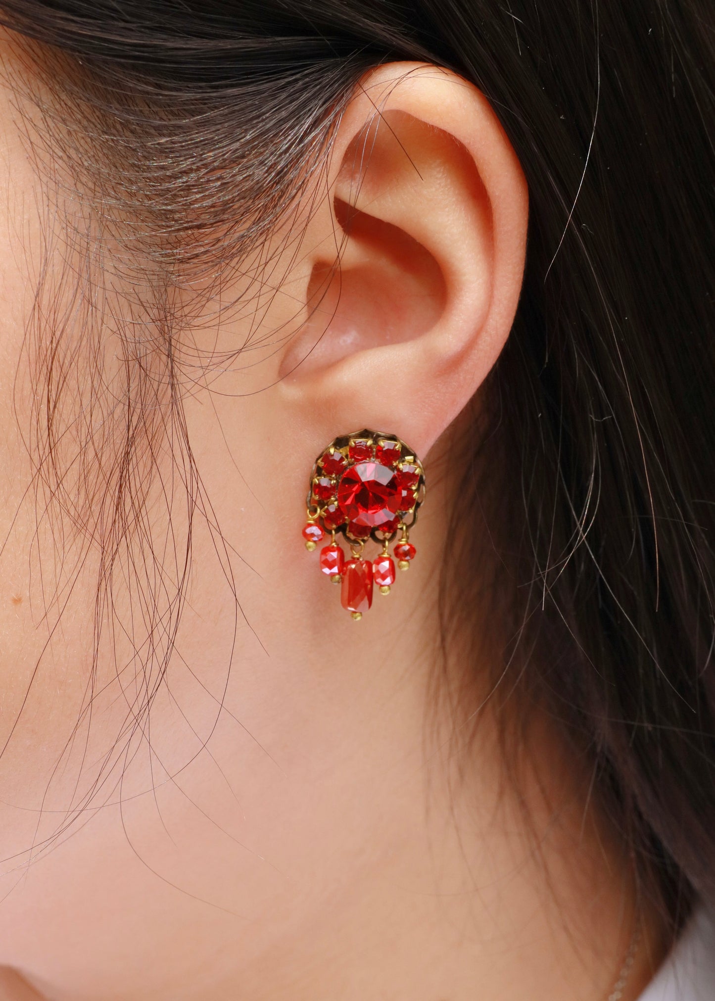 Orecchini artigianali Metropolitan Taormina rosso, con cristallo centrale, corona di strass e cinque pietre sfaccettate a cascata in rosso iridescente. Nickel free, stile mediterraneo per ogni occasione.