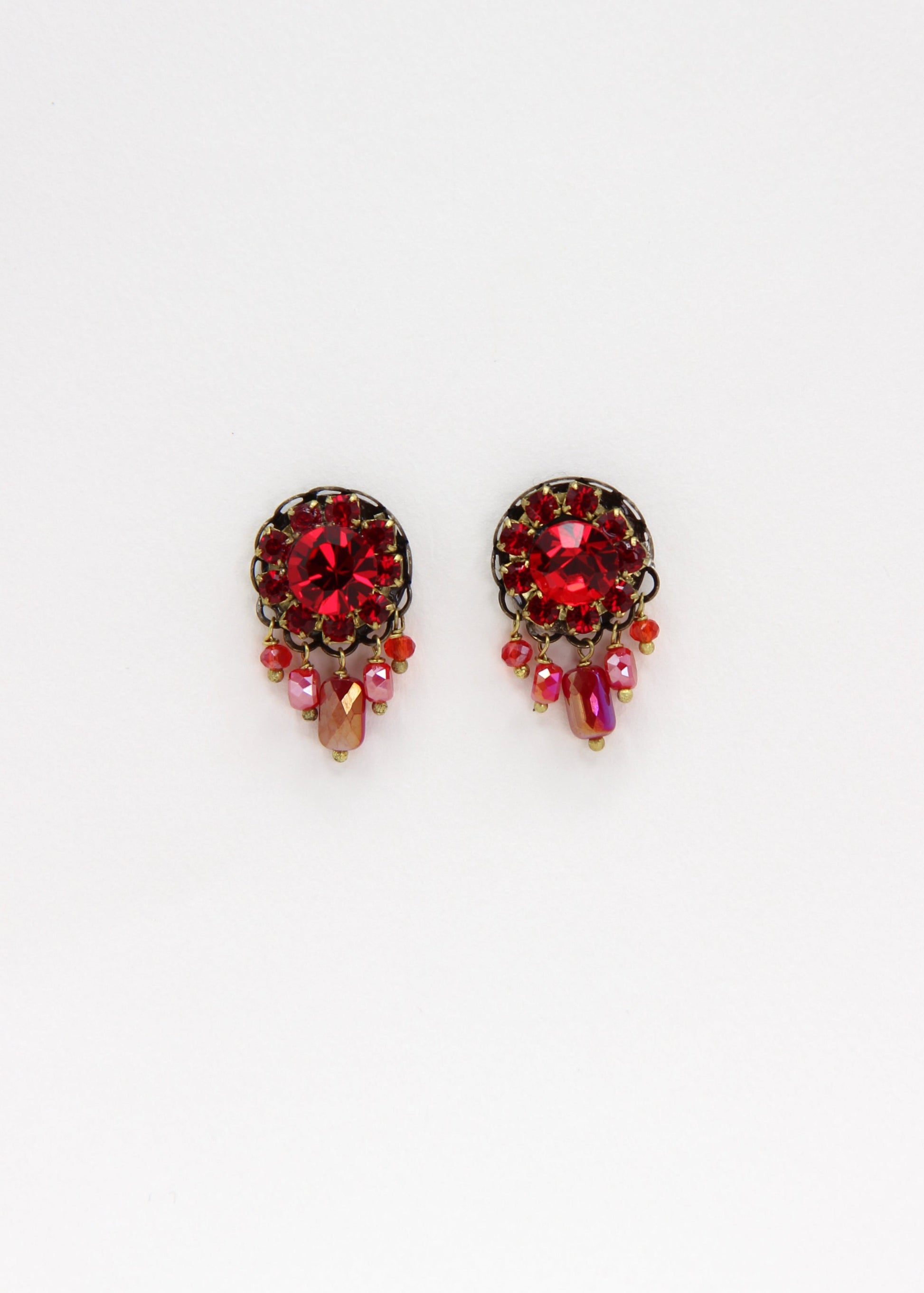 Orecchini artigianali Metropolitan Taormina rosso, con cristallo centrale, corona di strass e cinque pietre sfaccettate a cascata in rosso iridescente. Nickel free, stile mediterraneo per ogni occasione.