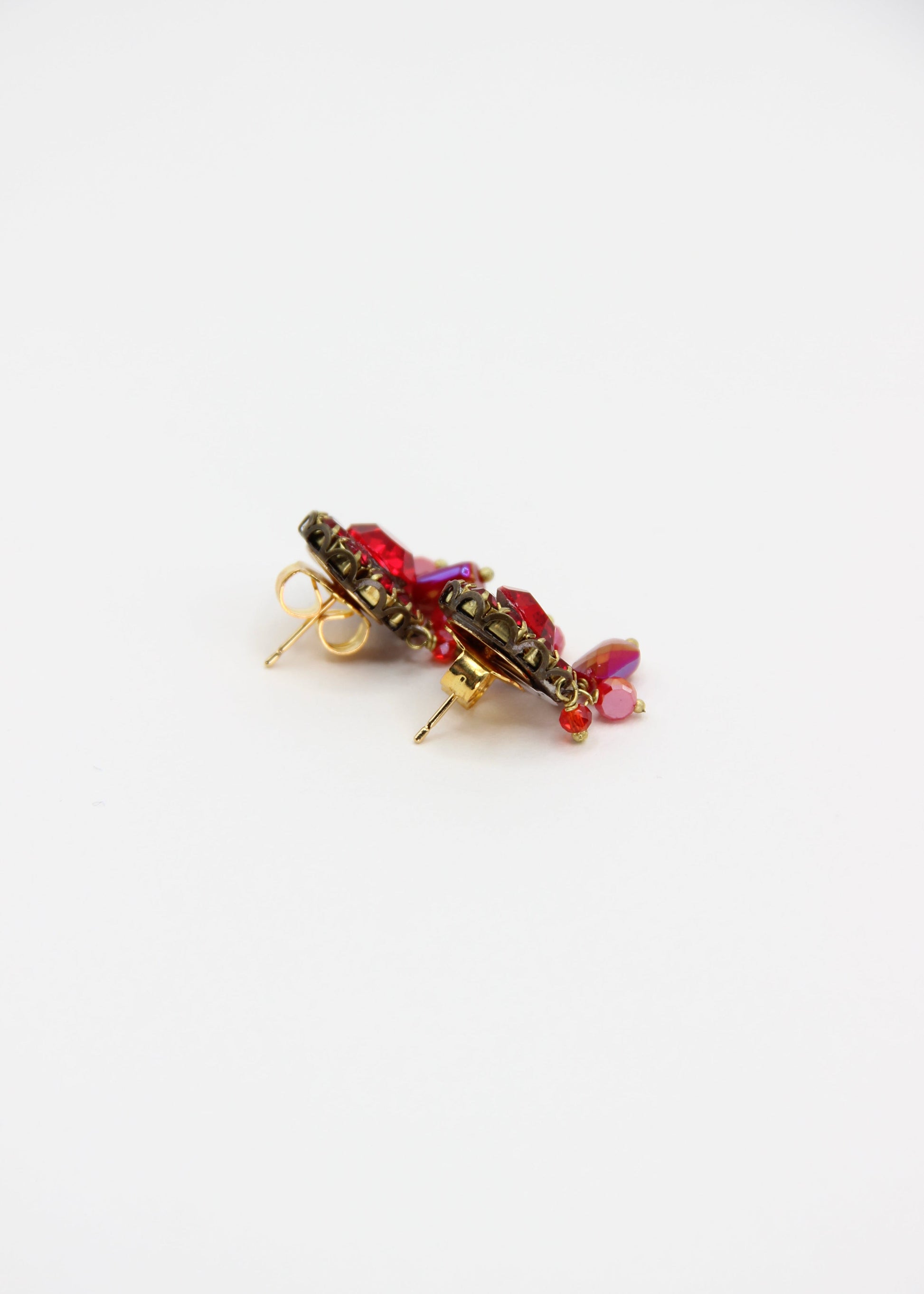 Orecchini artigianali Metropolitan Taormina rosso, con cristallo centrale, corona di strass e cinque pietre sfaccettate a cascata in rosso iridescente. Nickel free, stile mediterraneo per ogni occasione.