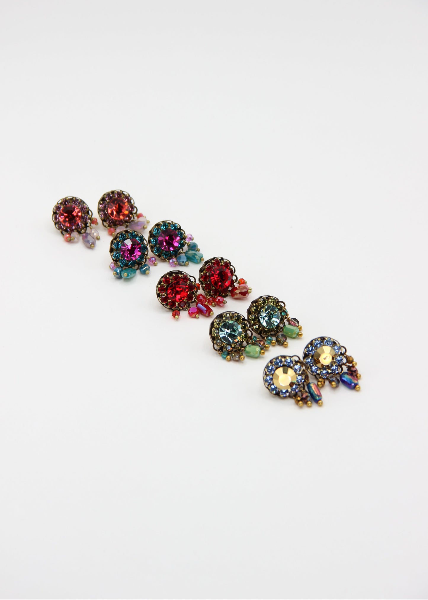 Orecchini artigianali Metropolitan Taormina rosso, con cristallo centrale, corona di strass e cinque pietre sfaccettate a cascata in rosso iridescente. Nickel free, stile mediterraneo per ogni occasione.